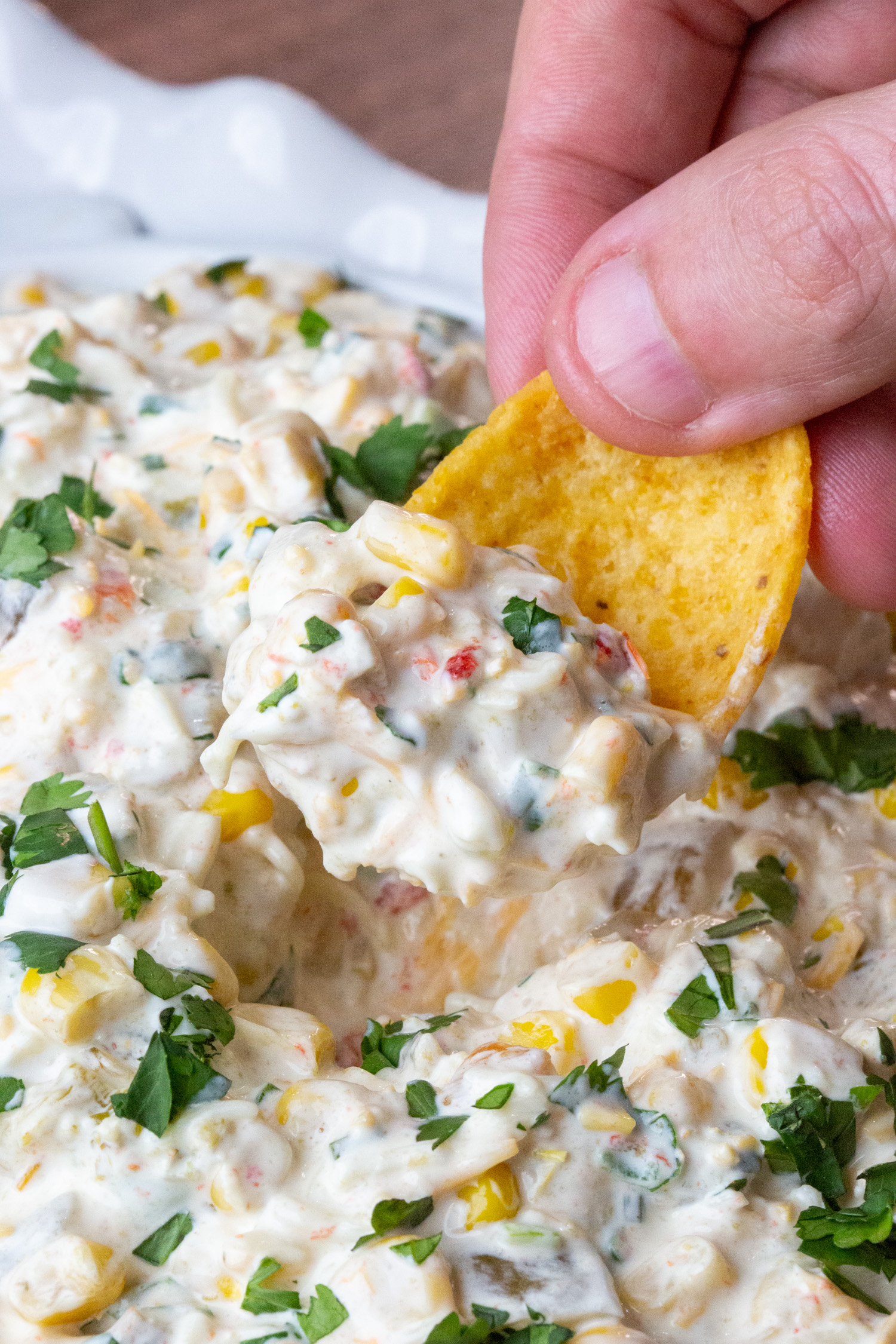 corn dip being scooped with a frito dip