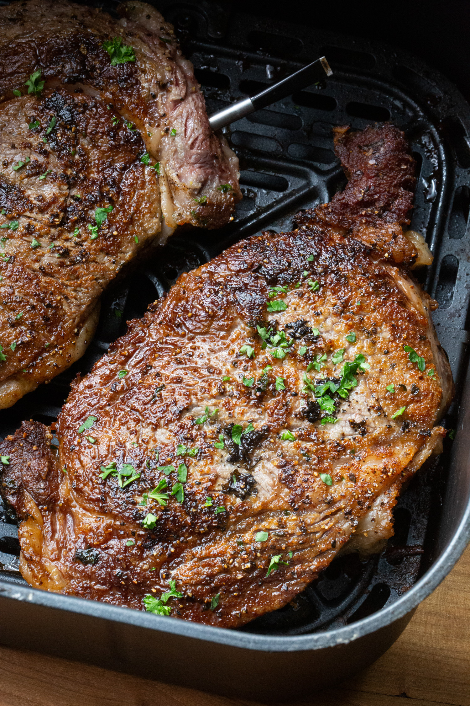 seared steaks inside on an airfryer basket