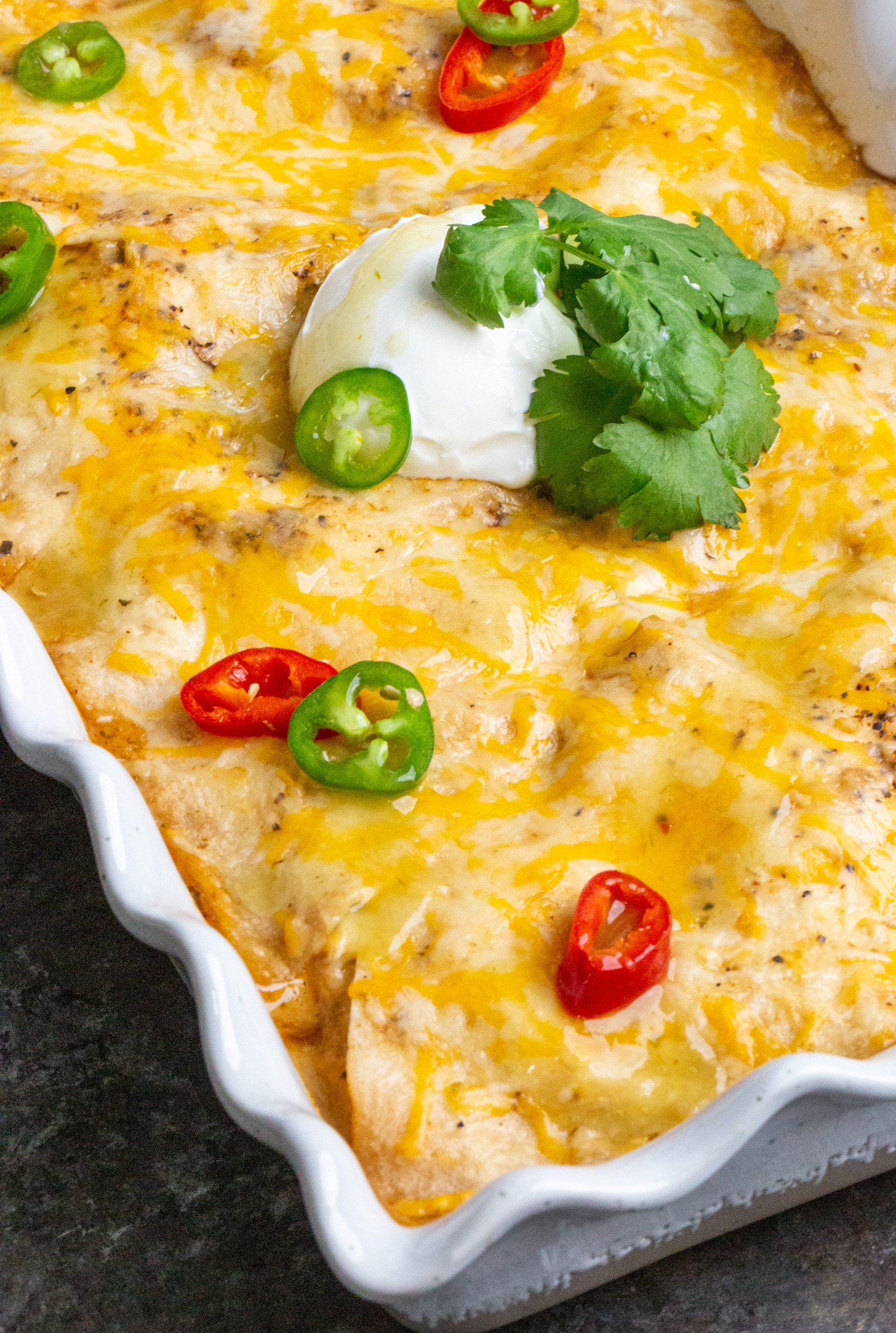 A large white baking dish filled with chicken fajita ingredients.