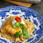 A slice of cheesy chicken fajita casserole on a pretty blue plate.