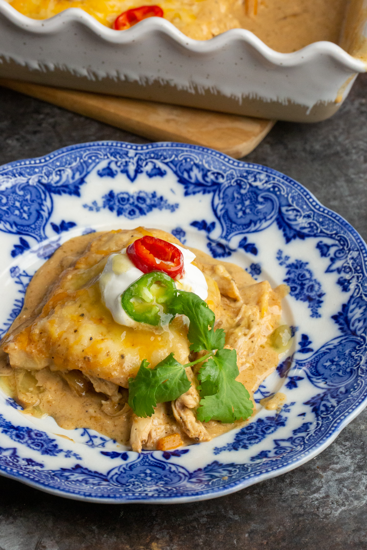 A slice of cheesy chicken fajita casserole on a pretty blue plate.