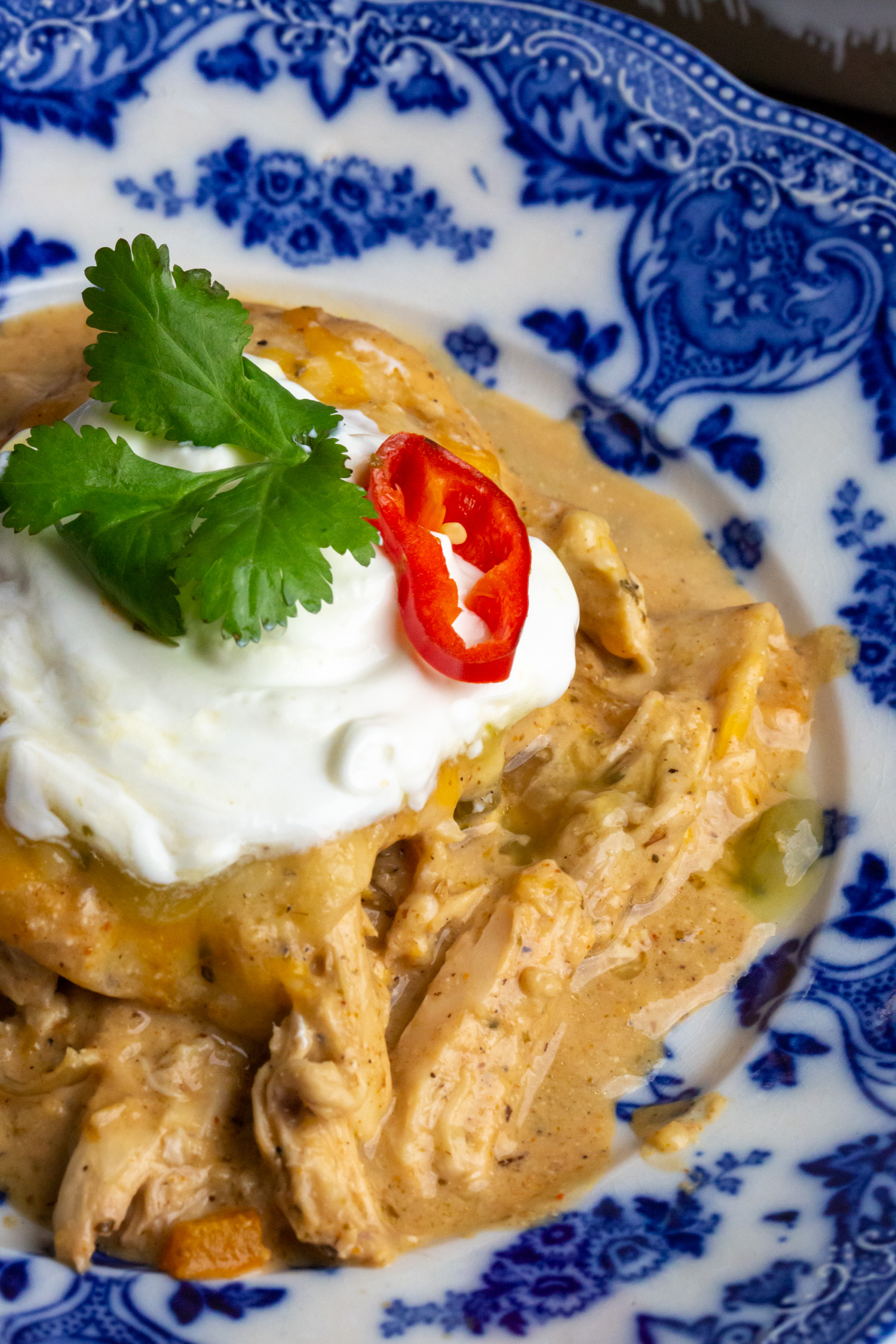 A close up of the layered low carb tortillas, tender chicken, and sour cream from this keto casserole.