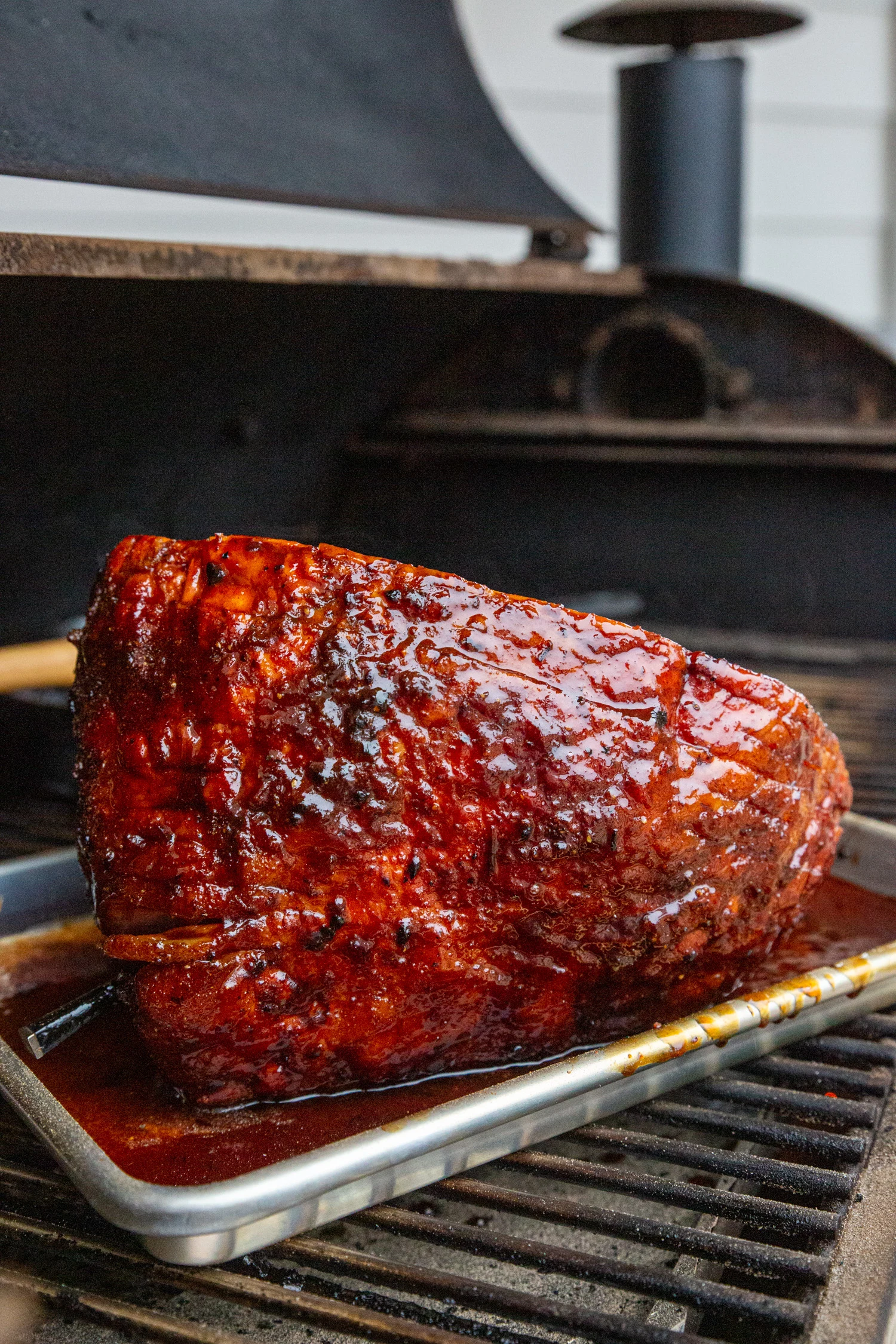 Beautiful rubbed and smoked ham on the smoker in the sunlight. 