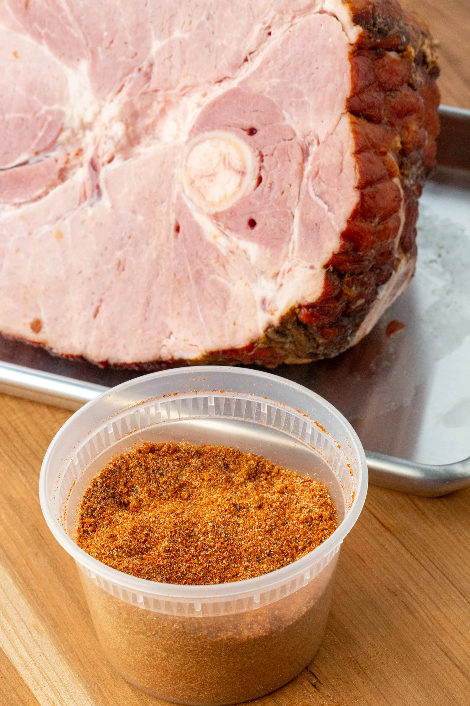 smoked ham rub next to a ham on a baking sheet