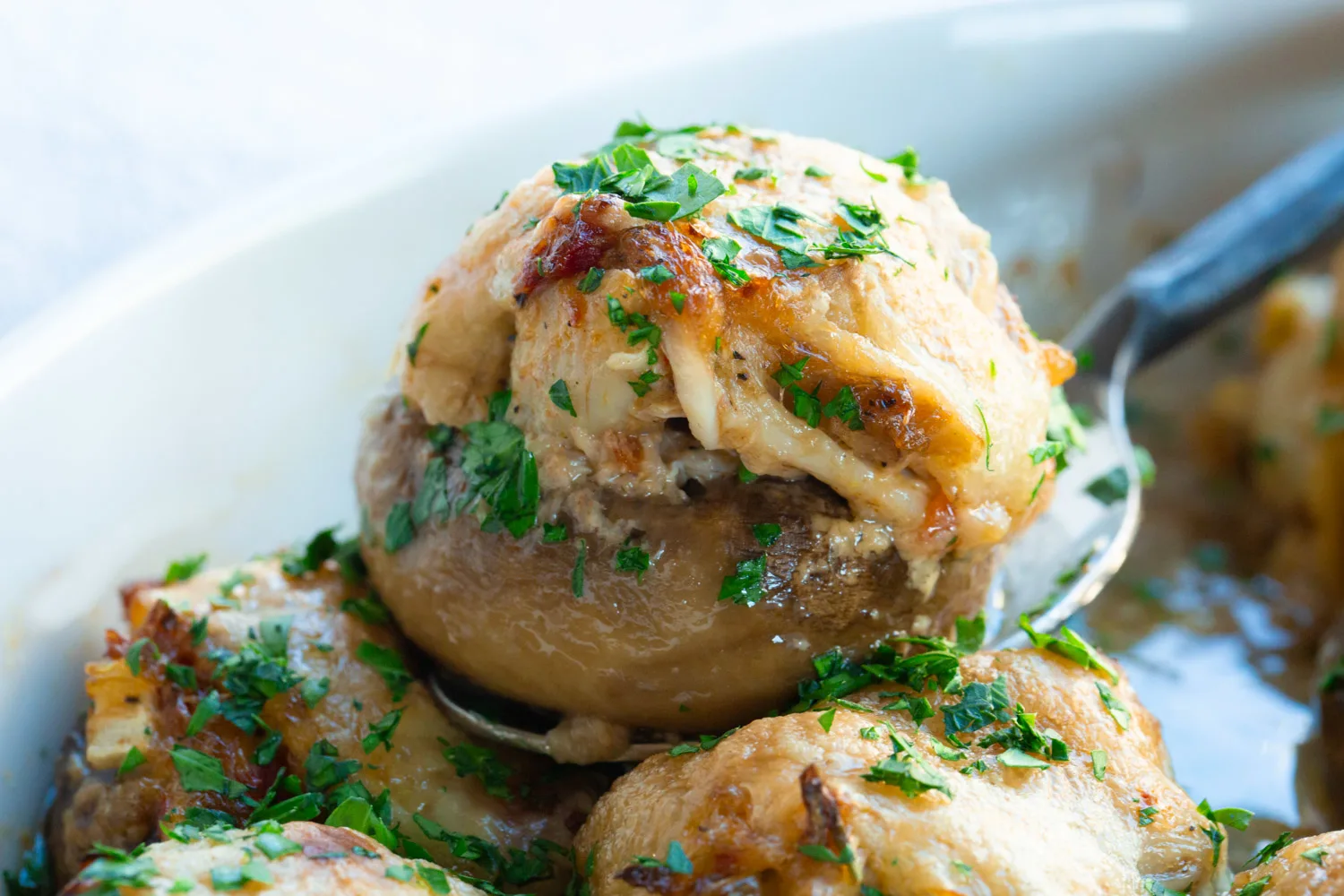Smaller mushrooms can make a great first course, shown in an olive oil baked crock with parsley, served with a spoon. 
