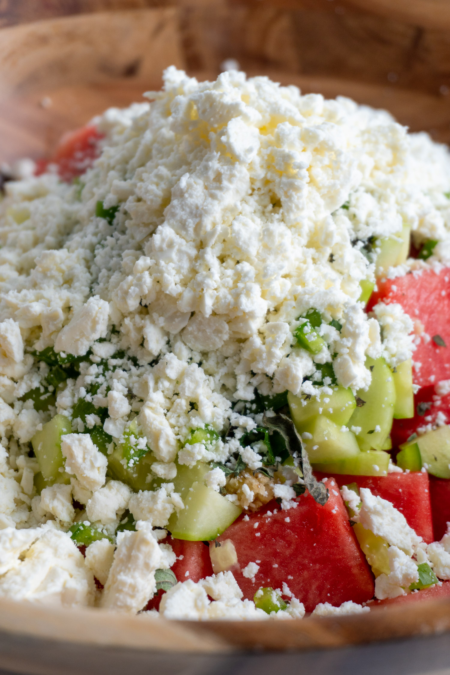 feta cheese sprinkled over watermelon and cucumber salad
