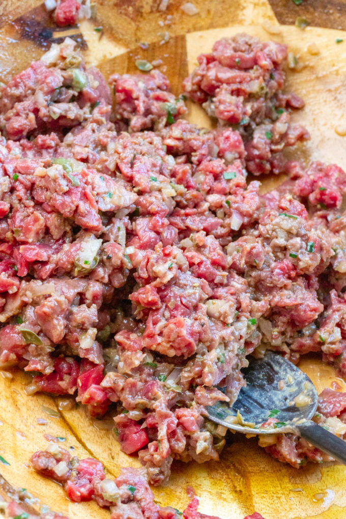 beef tartare mixed up in a bowl with chops