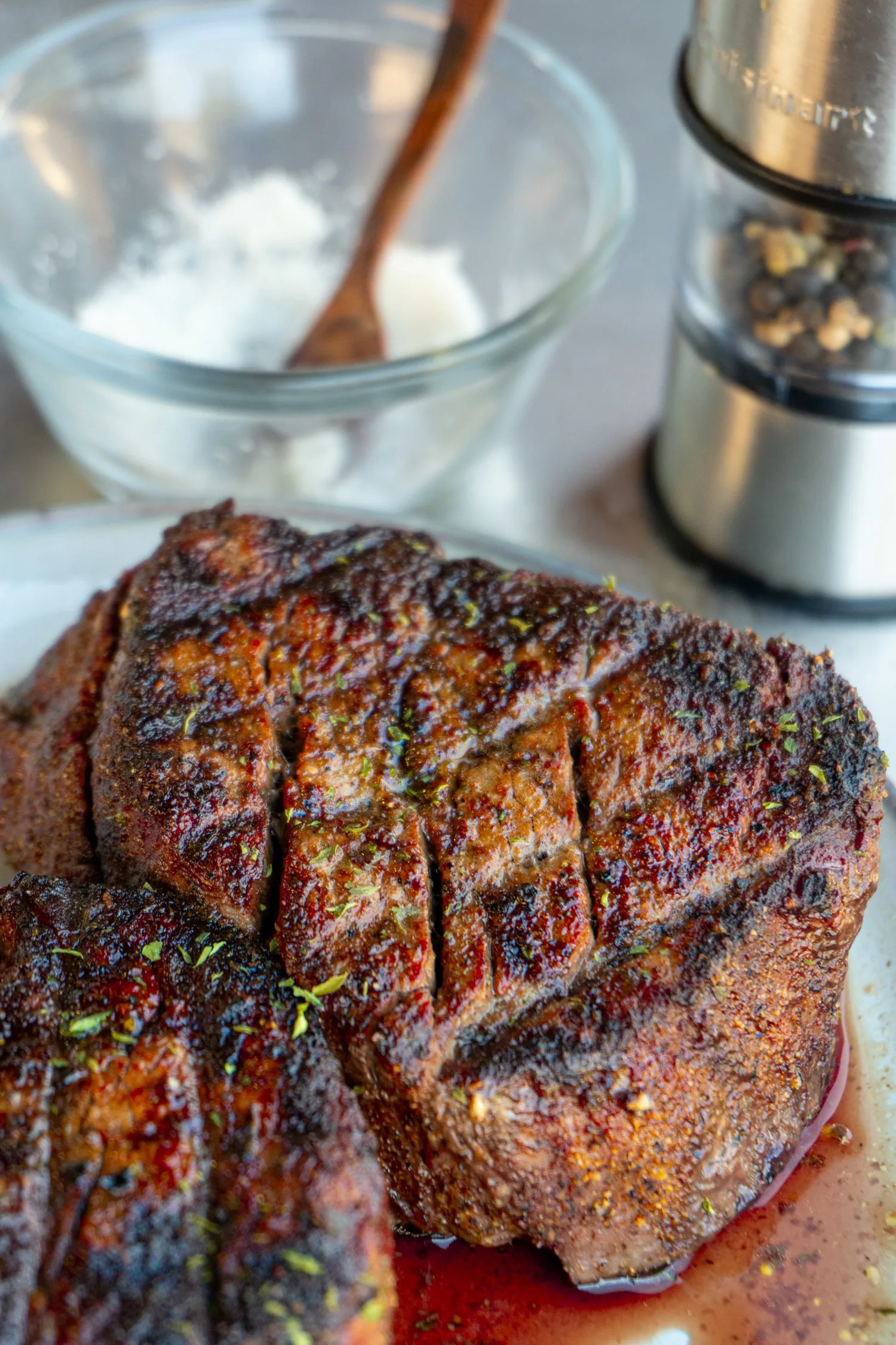 2 inch filet mignons, grilled and on a holding plate with salt and pepper behind them.