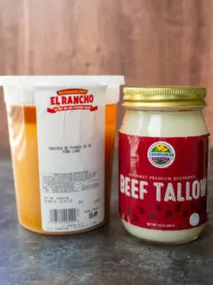 A container of fresh rendered pig fat and a jar of beef suet or tallow.