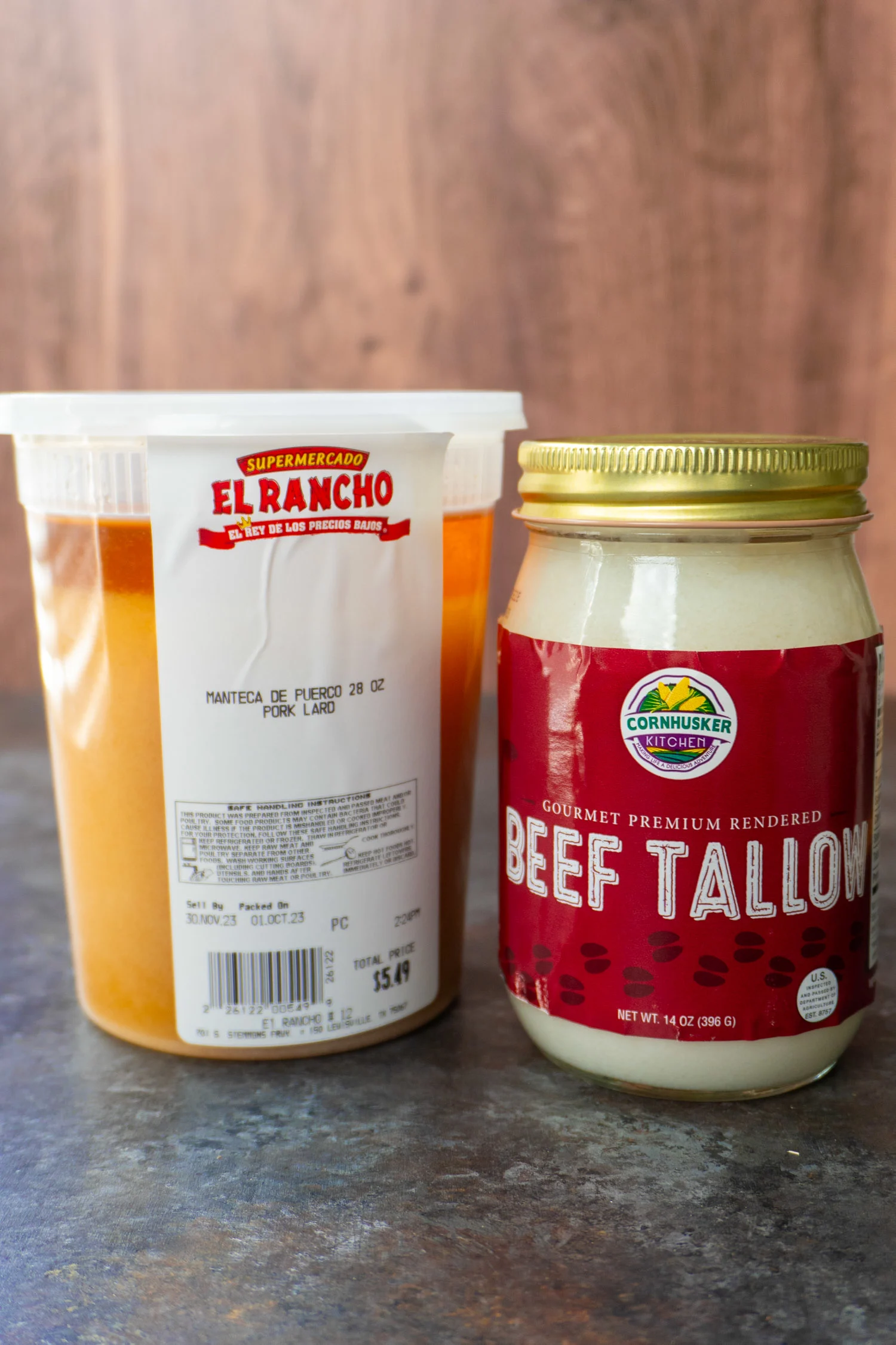 A container of fresh rendered pig fat and a jar of beef suet or tallow.