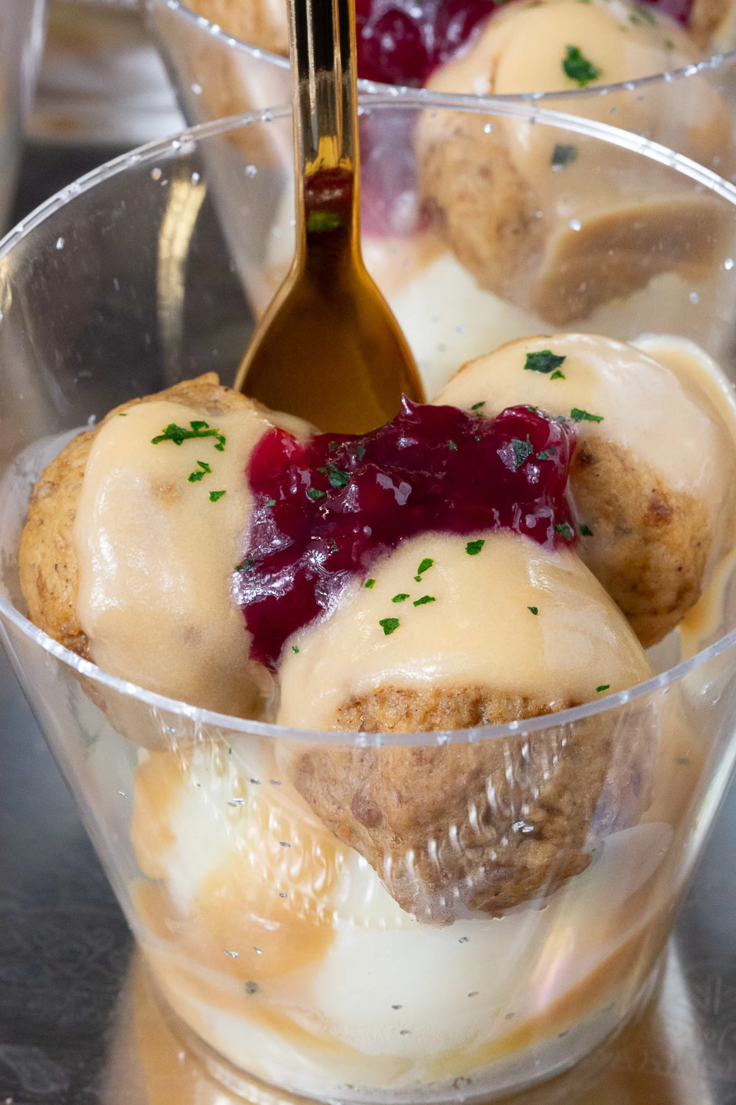 An upclose shot of a cup of ikea swedish meatballs made as a miniature appetizer.