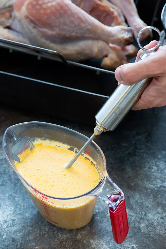 A hand drawing turkey injection into a syringe with a turkey in the background.