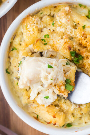 A close up of crab imperial portioned onto a spoon.