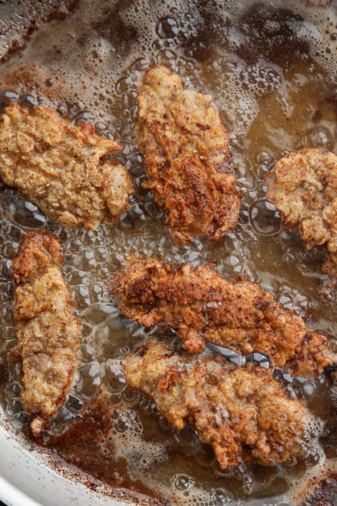 steak fingers in a skillet frying in oil