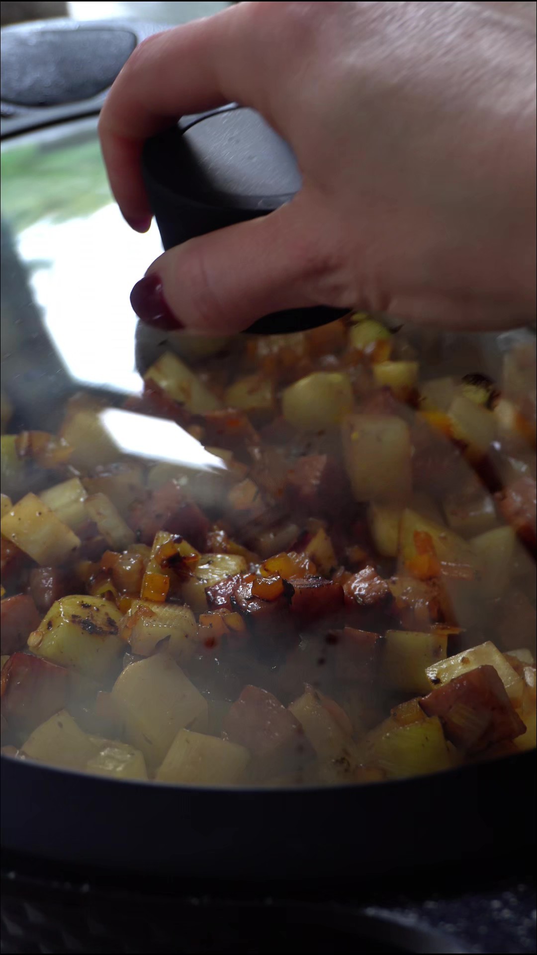 Placing the lid on the skillet to steam the potatoes