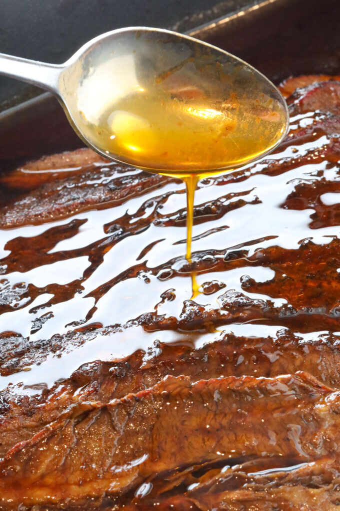 Spooning juices over the brisket as a pan sauce