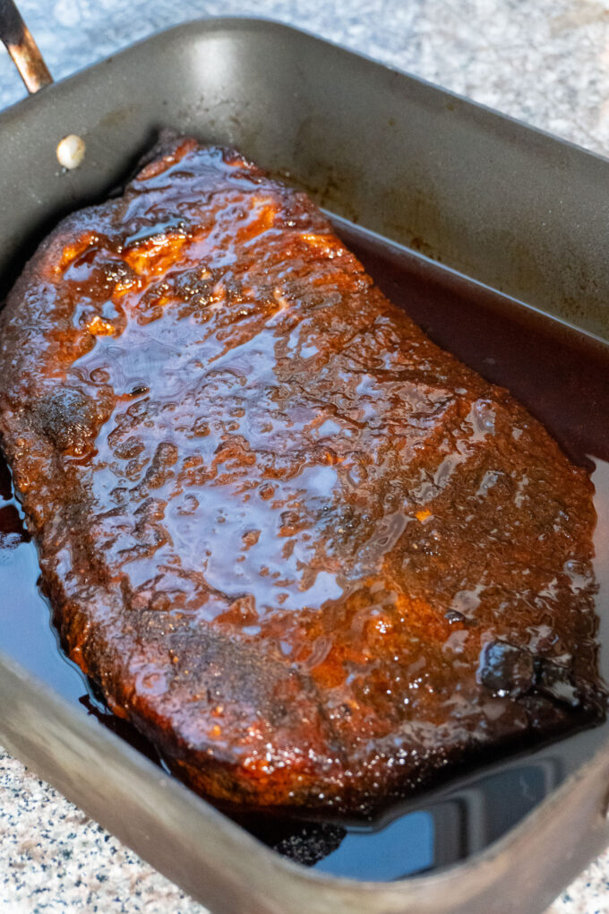 A completed brisket cooked thoroughly and resting in its juices