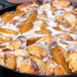 a close up of the cinnamon roll bake topped with icing