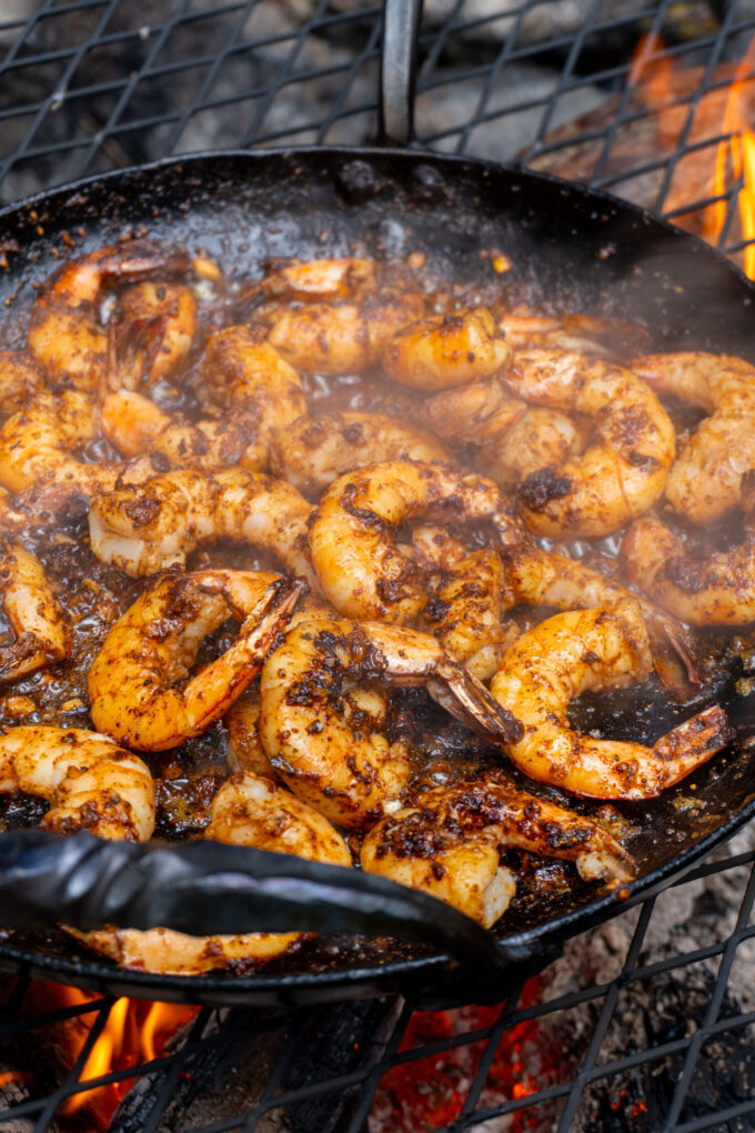 garlic and spiced shrimp sizzling in a hot buttered pan over a fire
