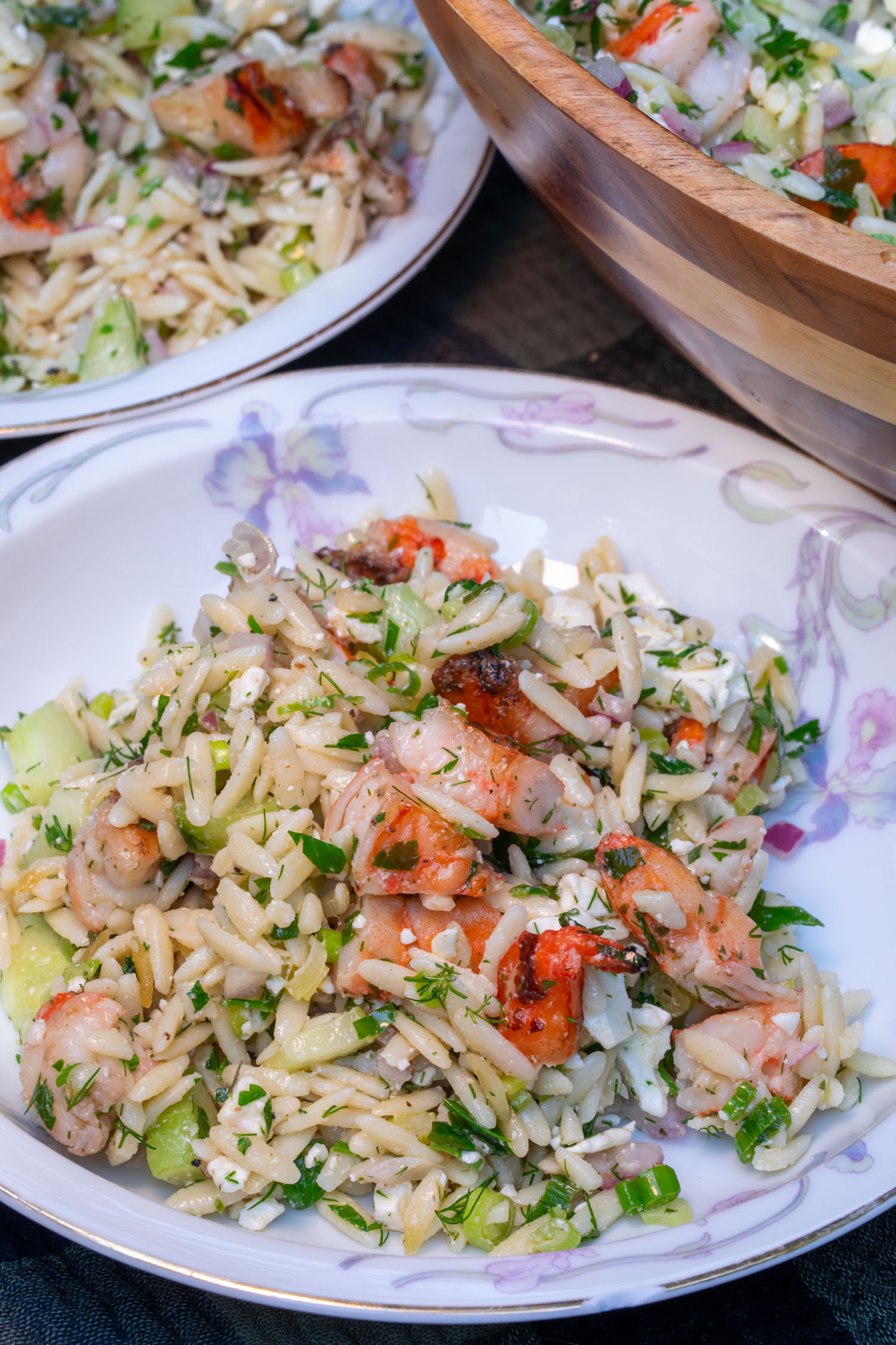 2 small bowls of orzo shrimp salad served from the bowl.