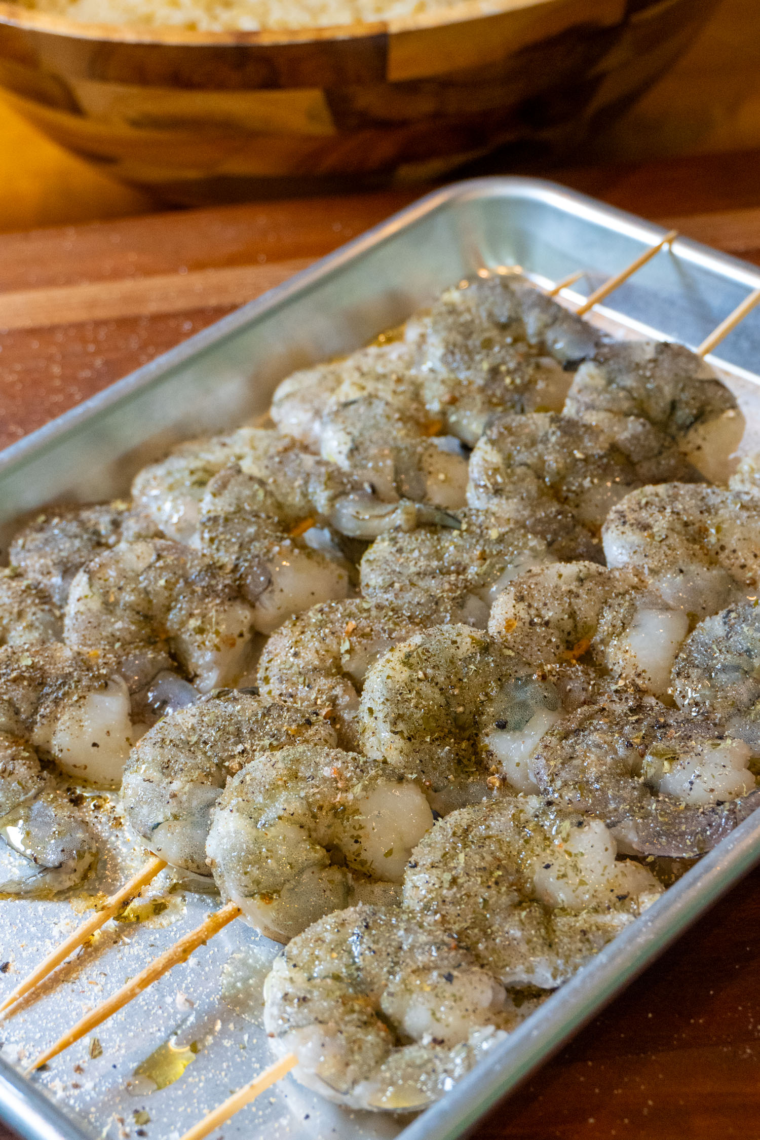 Raw shrimp on skewers, seasoned and ready to go out to the grill.