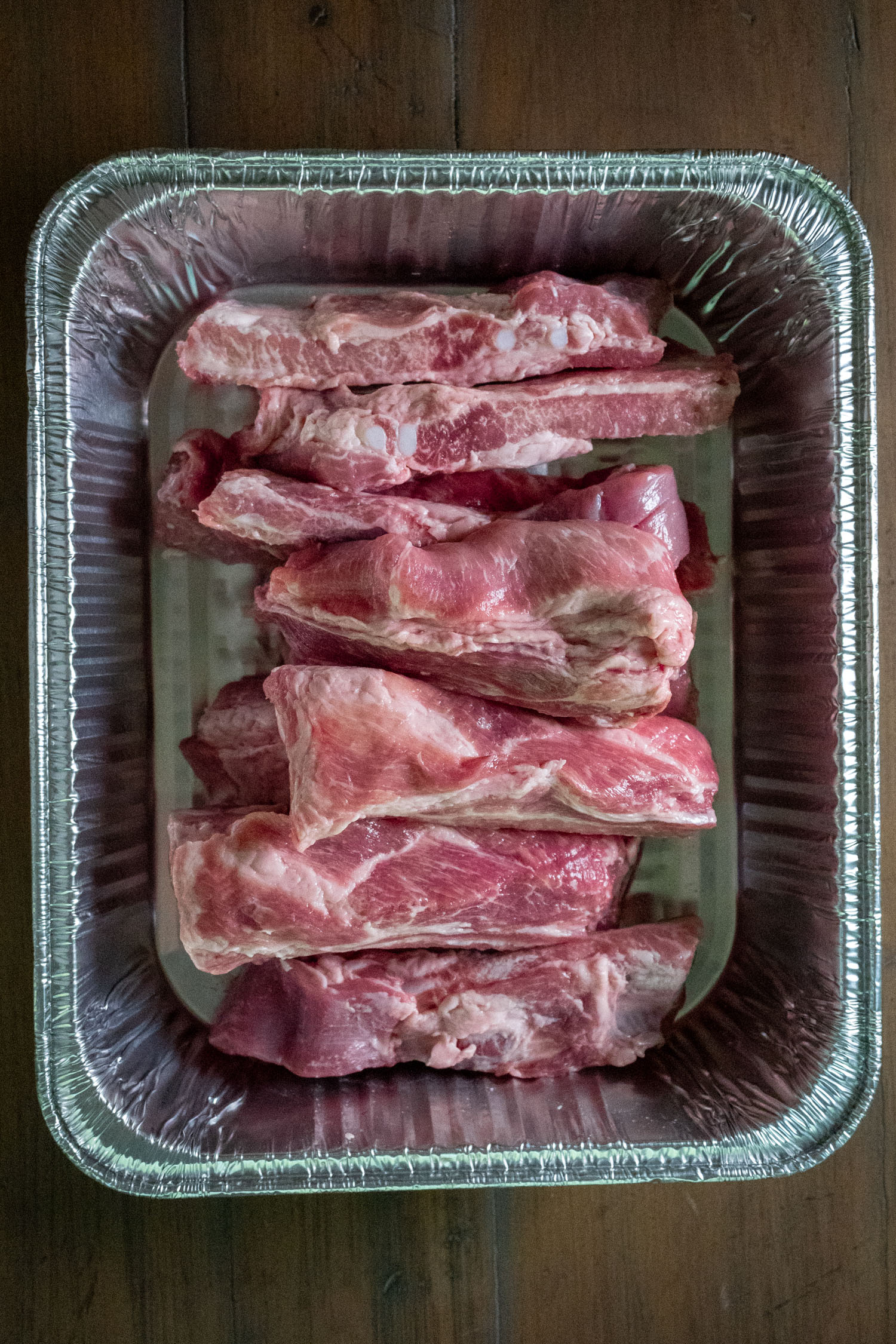 A foil pan of raw riblets