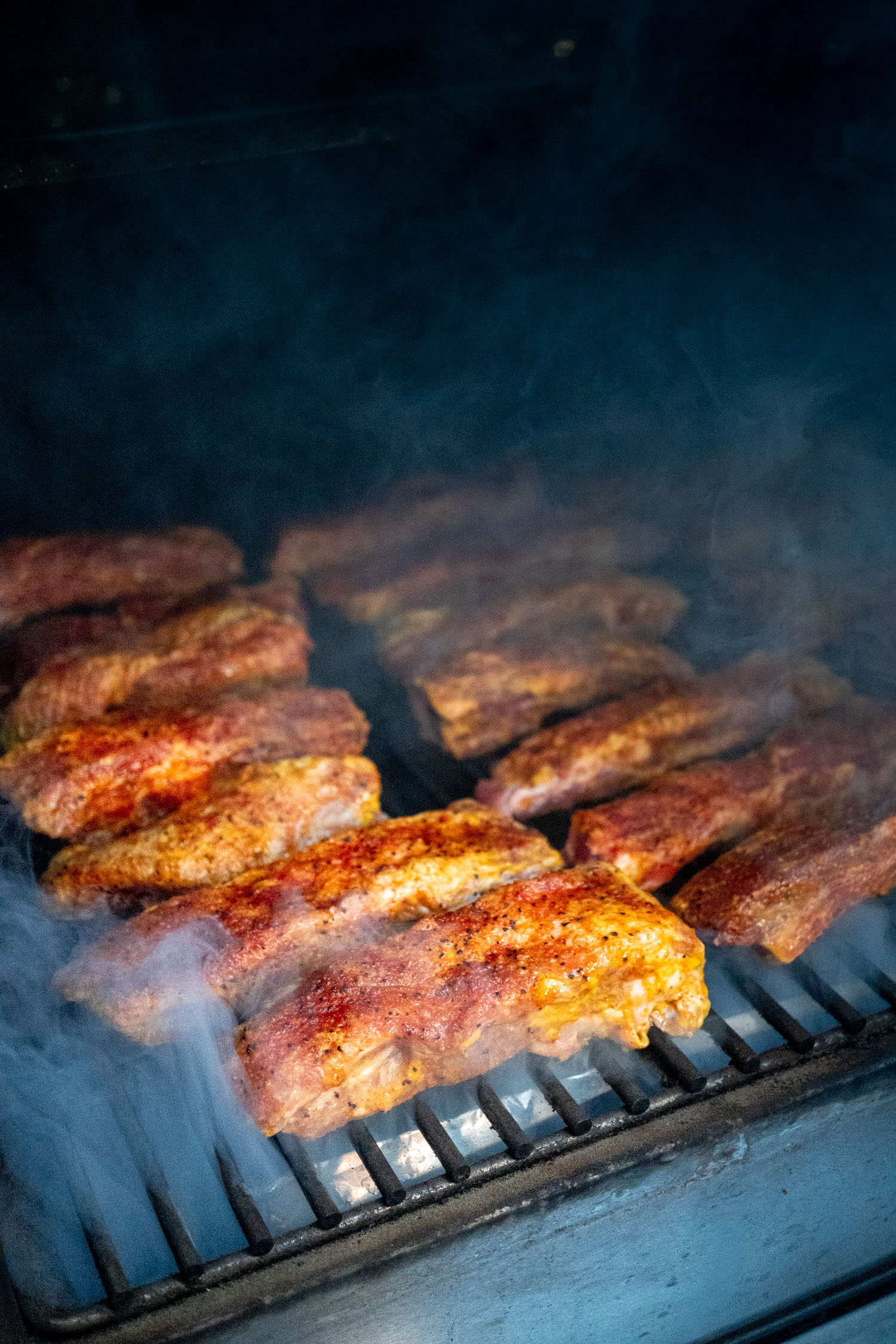 A barbecue smoker filled with party ribs