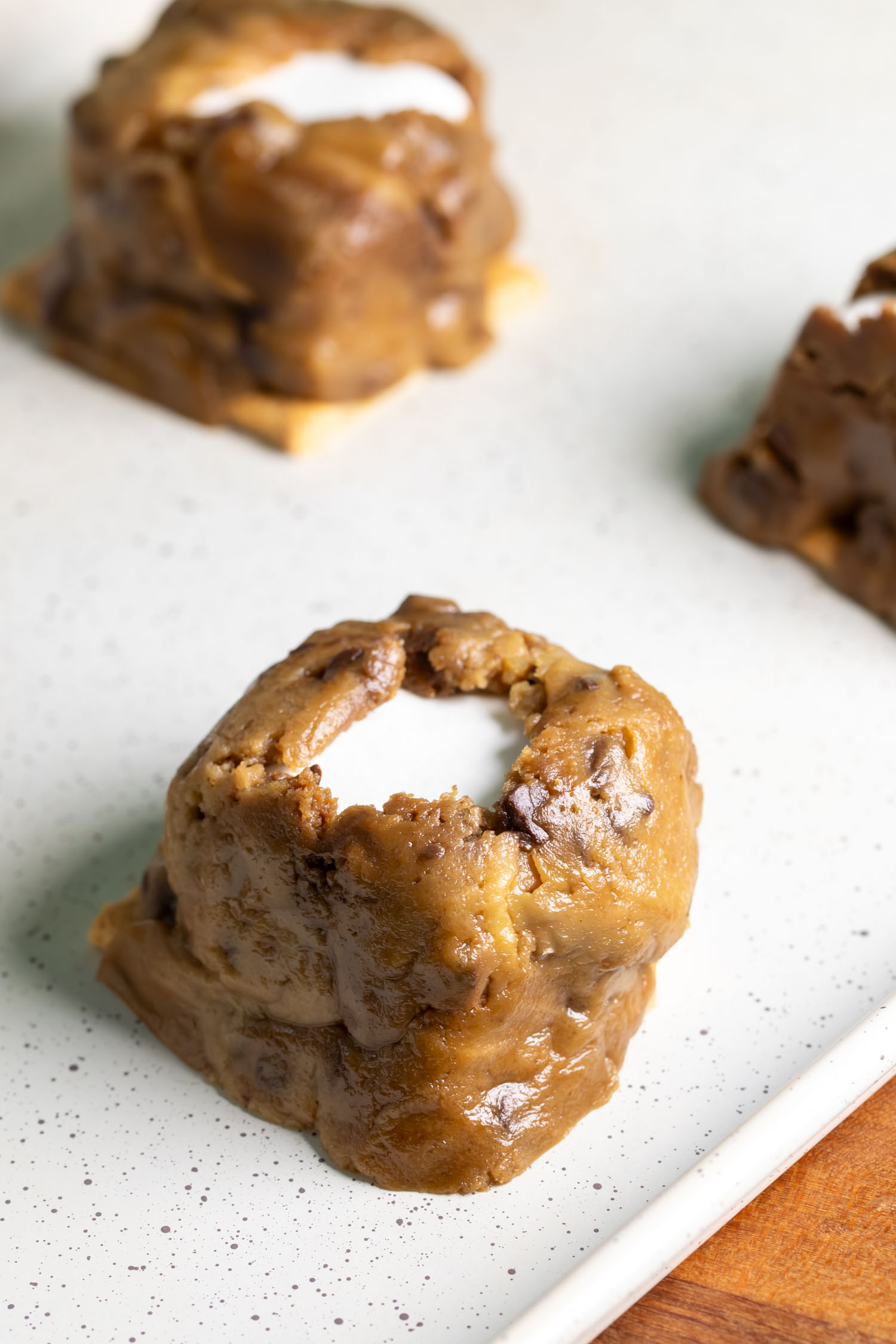 A smores build topped with cookie dough and poked through to expose the mashmallow