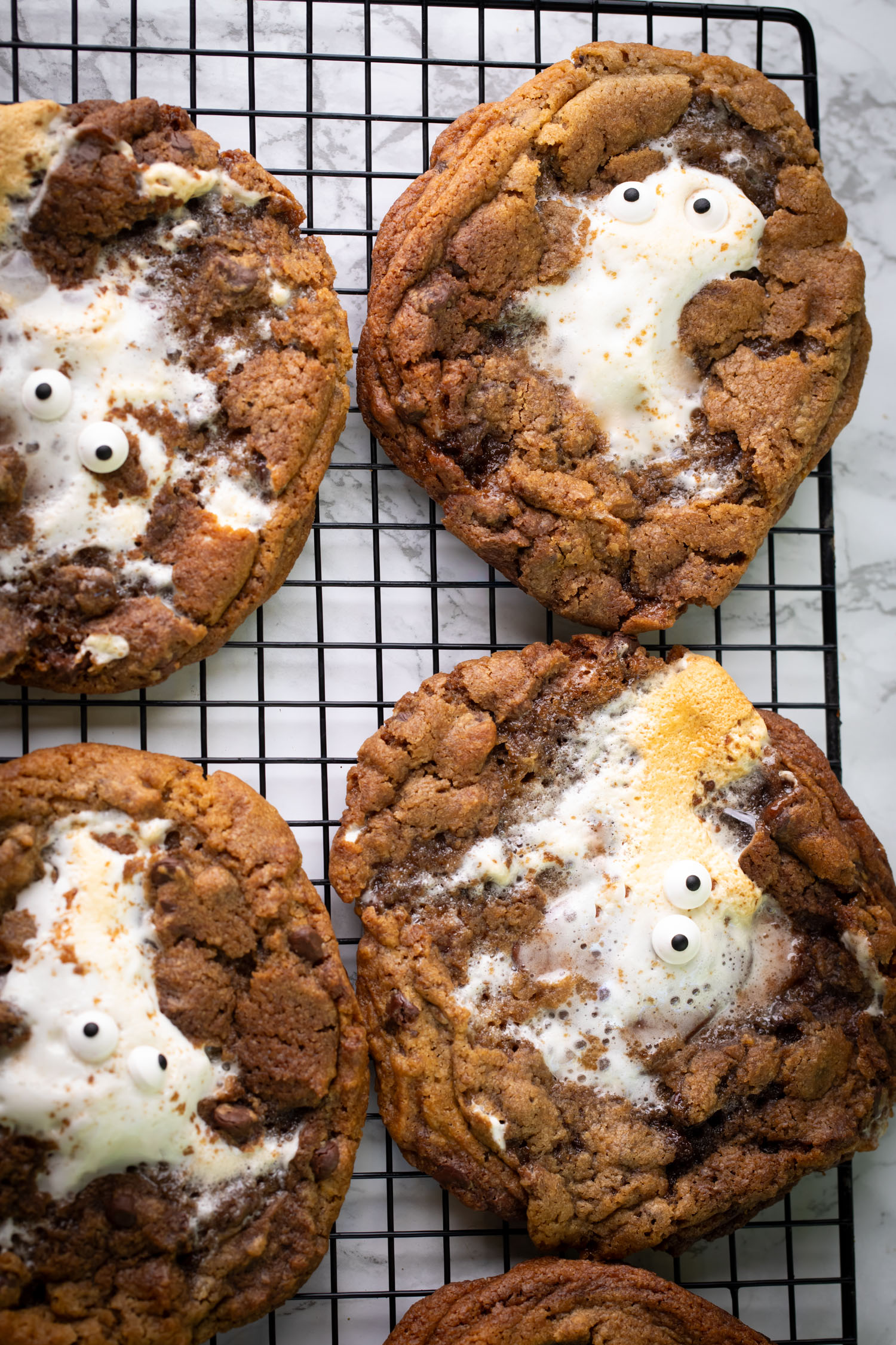A cooling rack of smores cookies with the eyeballs added for a spooky touch